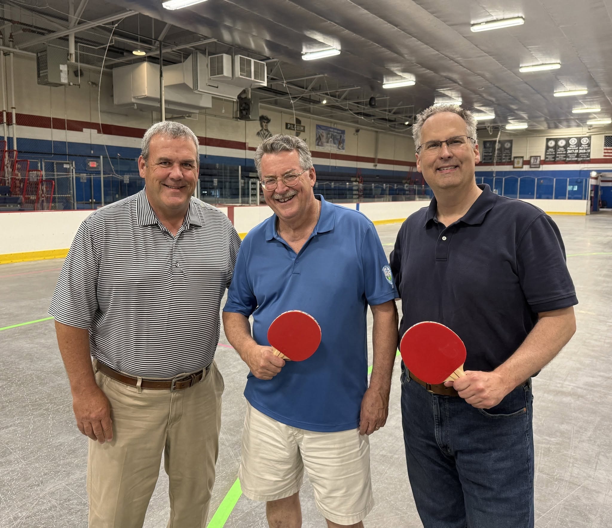 Three men with ping pong paddles