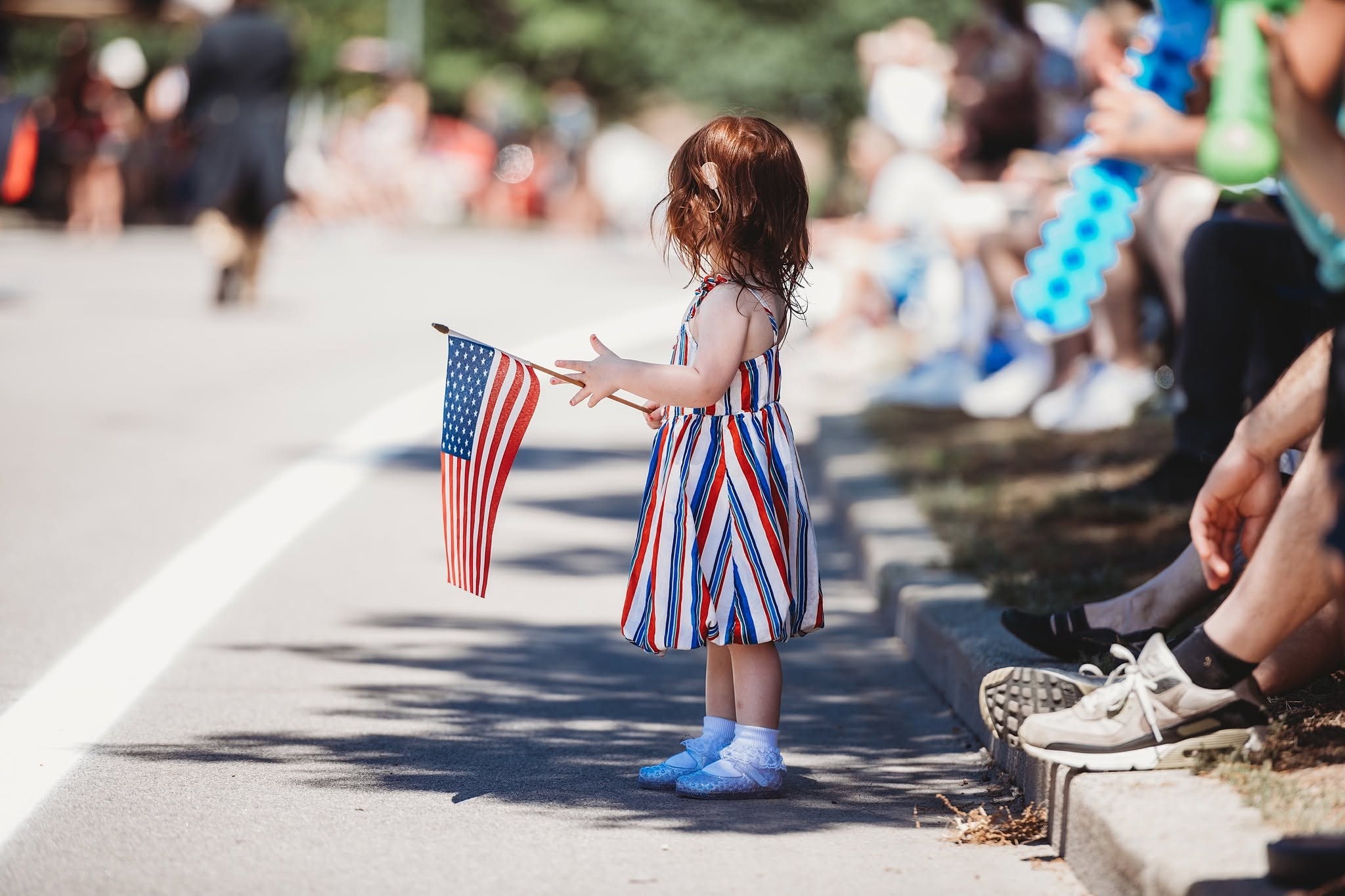 Child holding American flag at parade