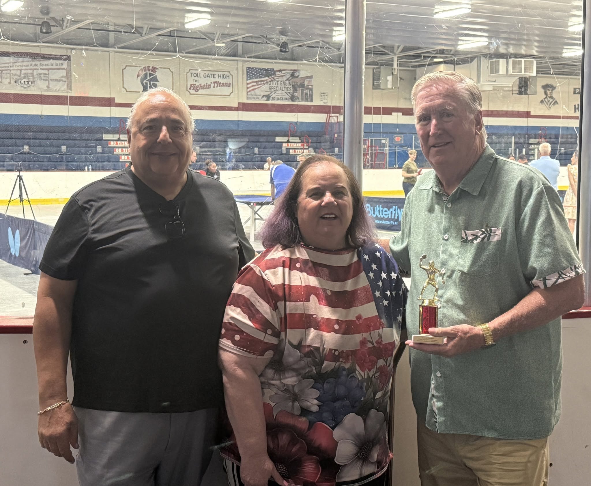 Three people posing at ice hockey arena