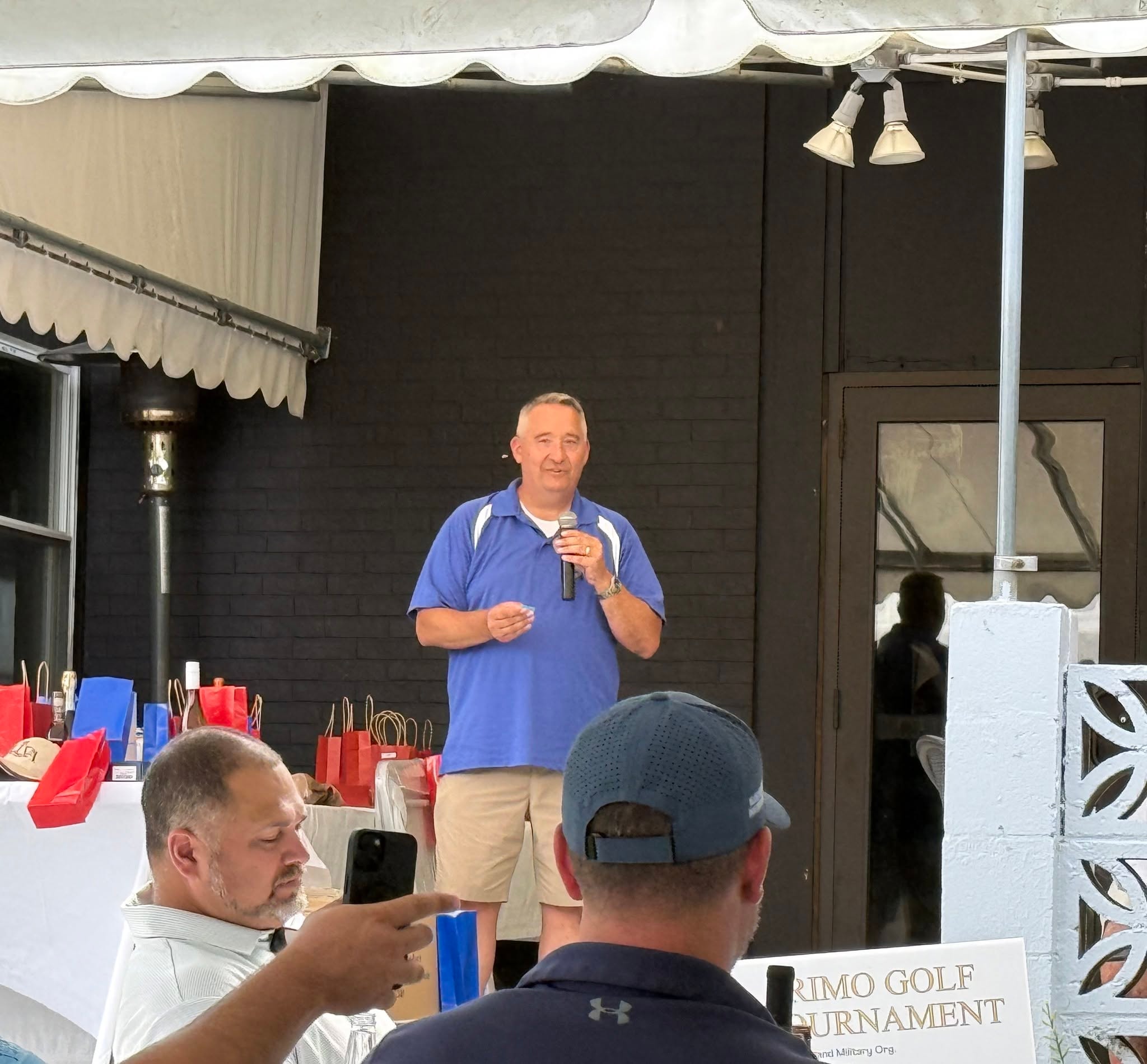 Man speaking at outdoor event tent